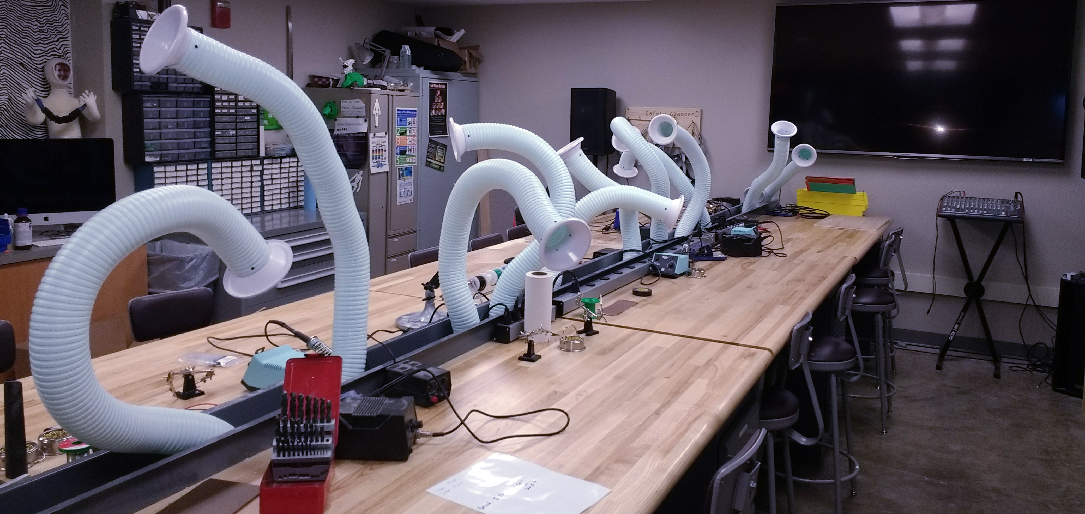 A makerspace with lots of fume snorkels artfully arranged