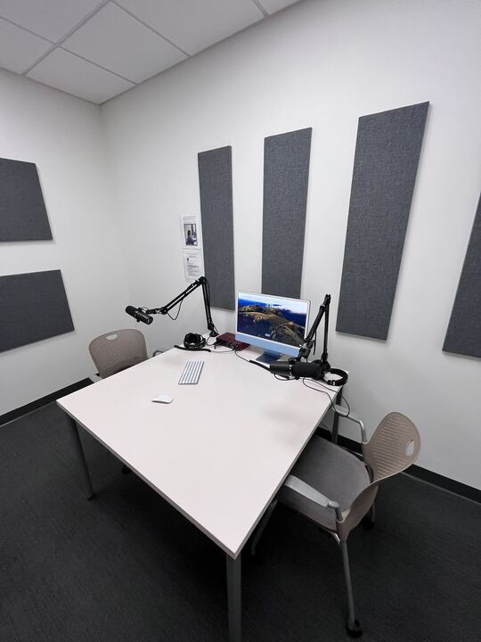 Image of the podcast studio with an imac and two mics