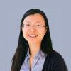 photo of Fang a woman with black hair wearing glasses against a blue background